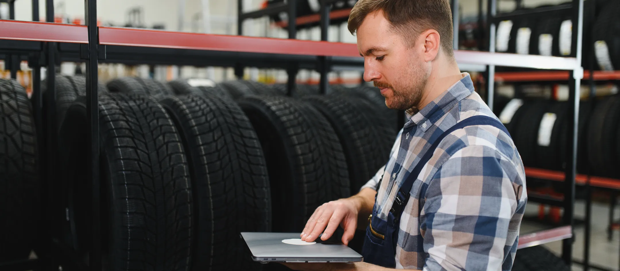 Worker using a tablet at tire shelves