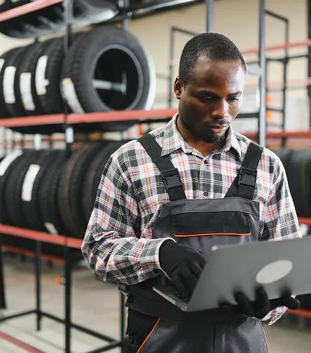 Worker using a laptop by tire racks