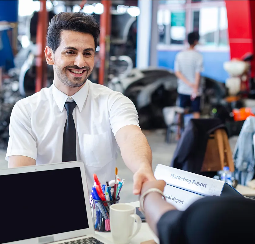 Service advisor handing over a report in an auto service shop