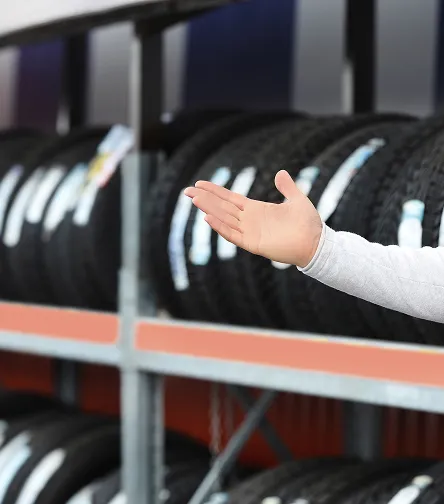 Hand selecting a tire from a shelf