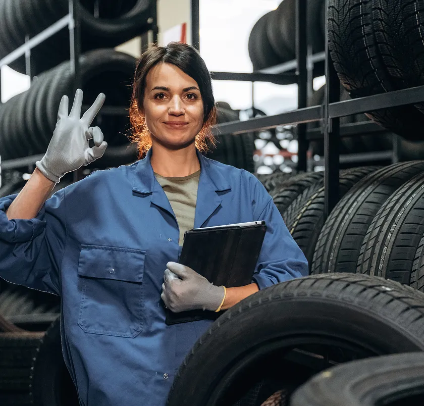 Worker holding a tablet beside a tire rack