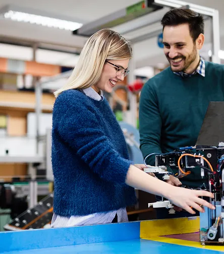 Two colleagues assembling electronics at a workbench