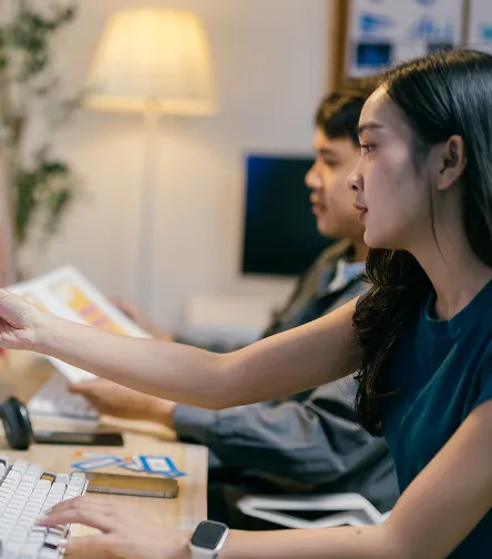 Two colleagues reviewing documents at a desk