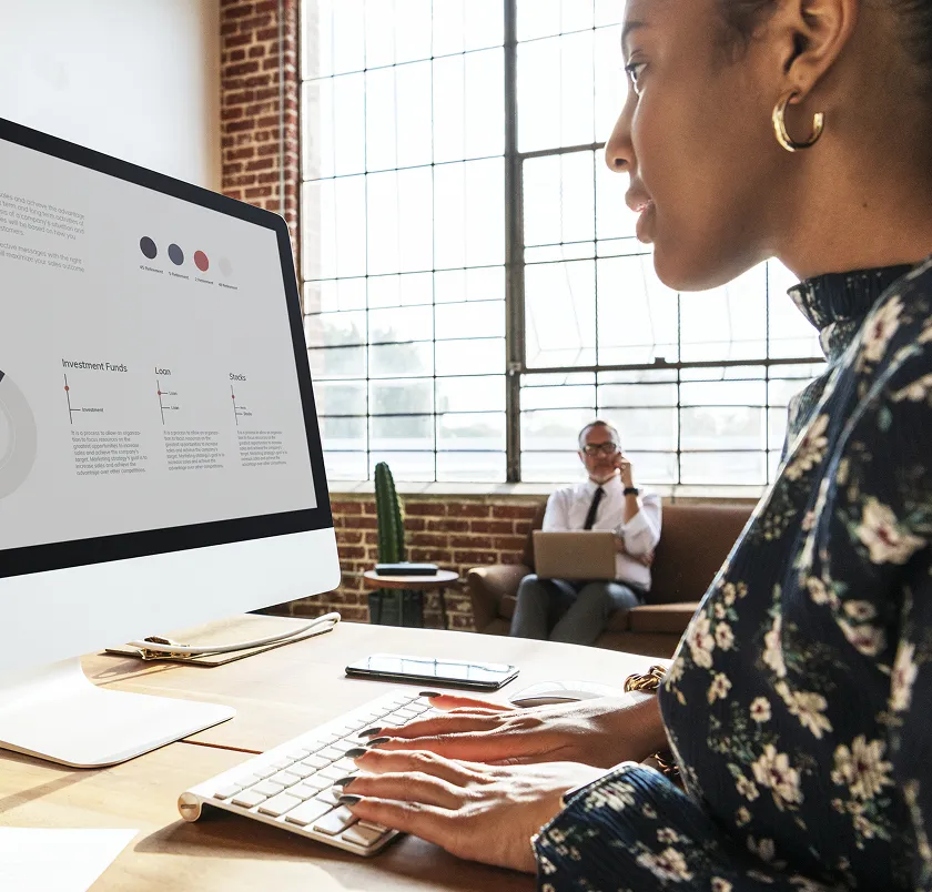 Woman viewing a website on a desktop monitor at her desk