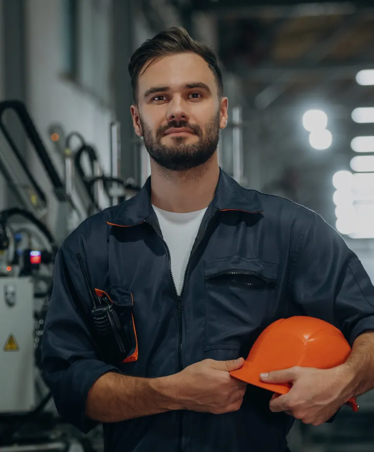 Worker holding a hard hat in a manufacturing plant