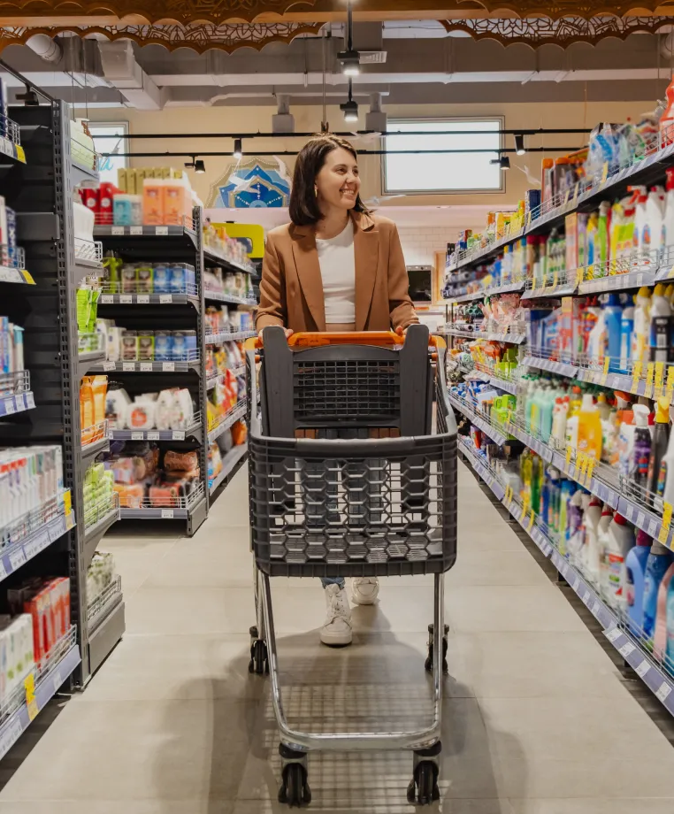 Shopper pushing a trolley in a supermarket aisle