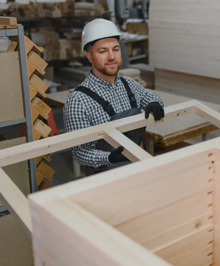 Worker in a hard hat assembling a wooden crate
