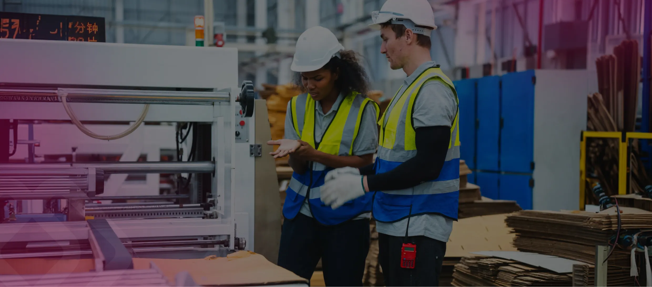 Two workers in hi-vis by machinery