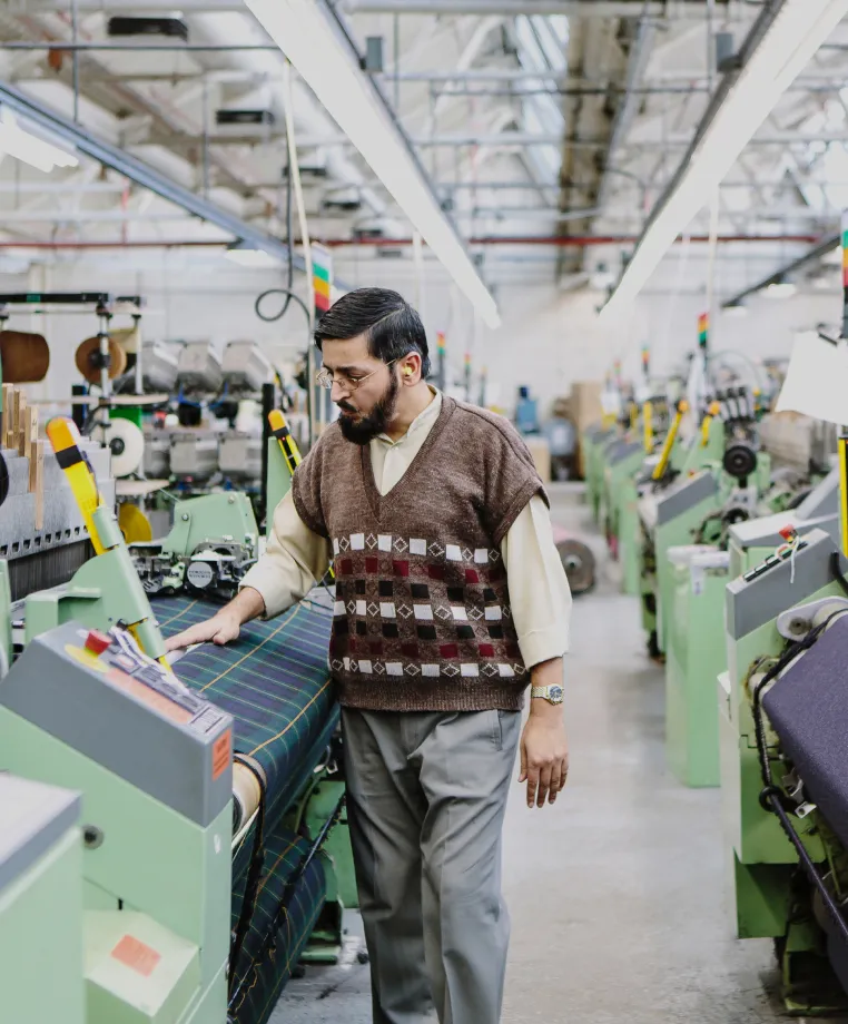 Worker operating a textile manufacturing machine