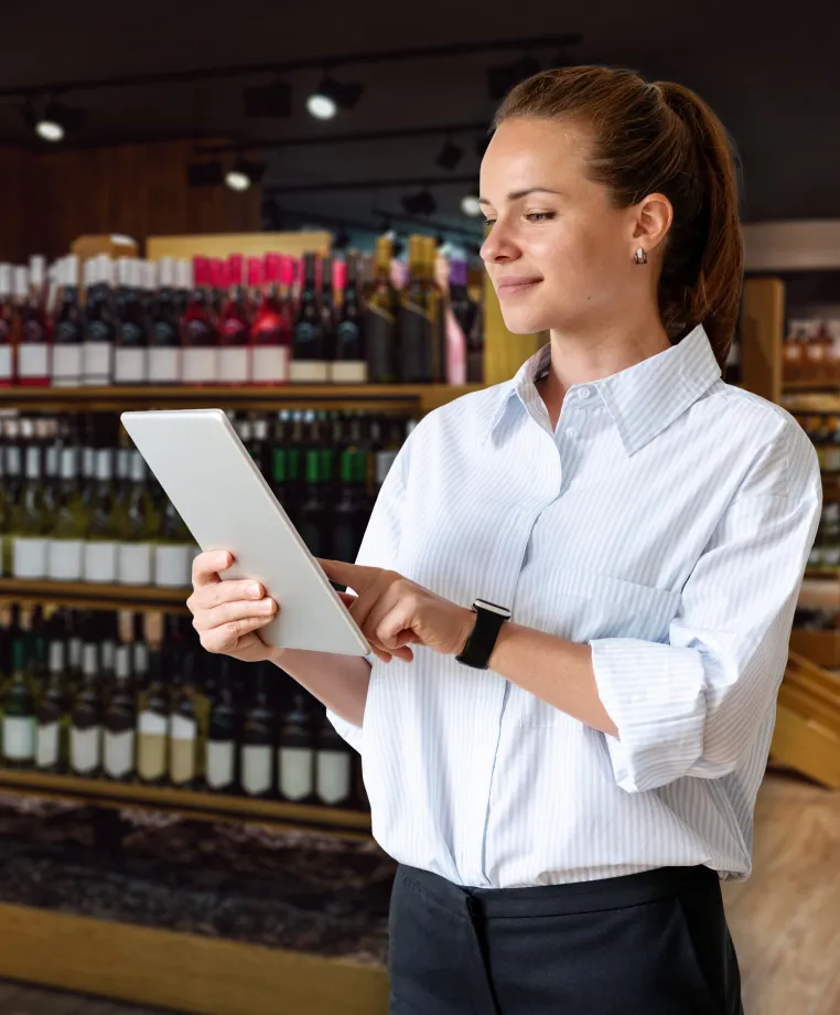 Shop assistant using a tablet in a wine store
