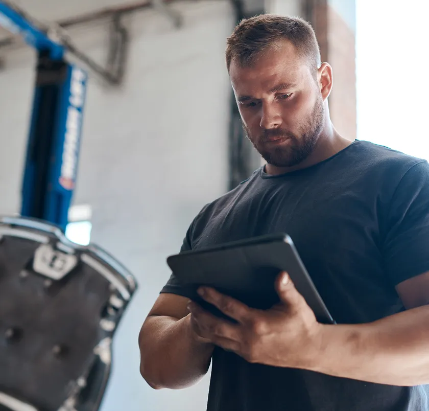 Man reviewing information on a tablet in a workshop