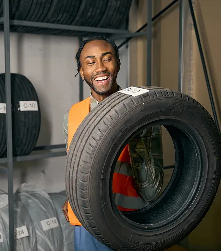 Smiling worker holding a tyre