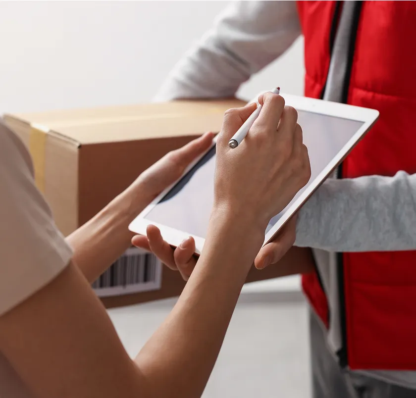 Delivery worker checking a parcel against a tablet