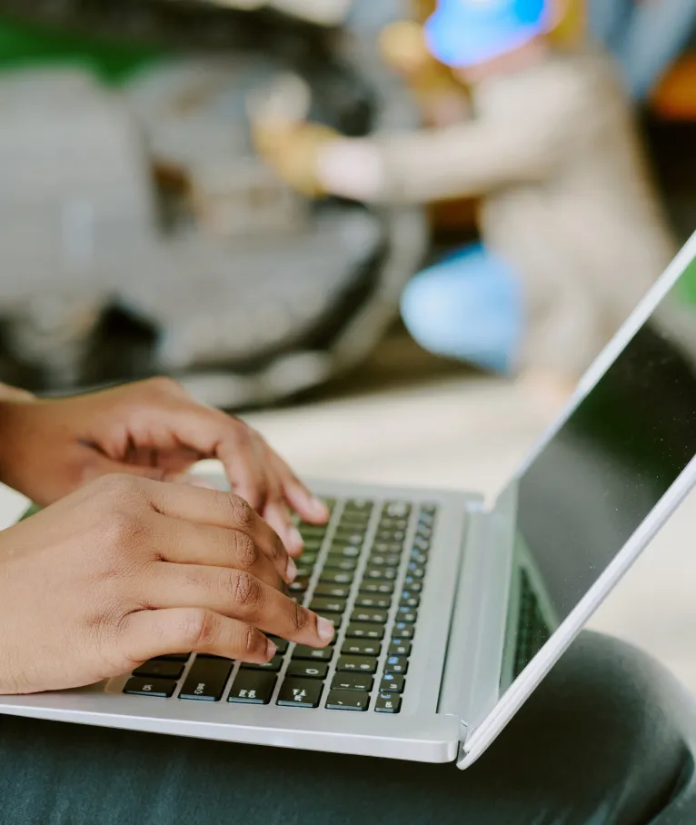 Close-up of hands typing on a laptop