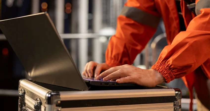 Worker using a laptop on a flight case