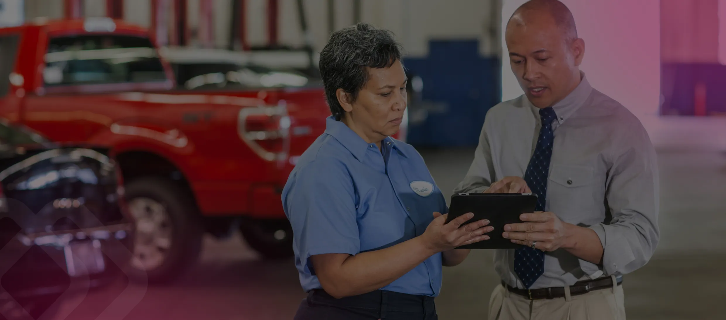 Colleagues reviewing details at a vehicle in a workshop