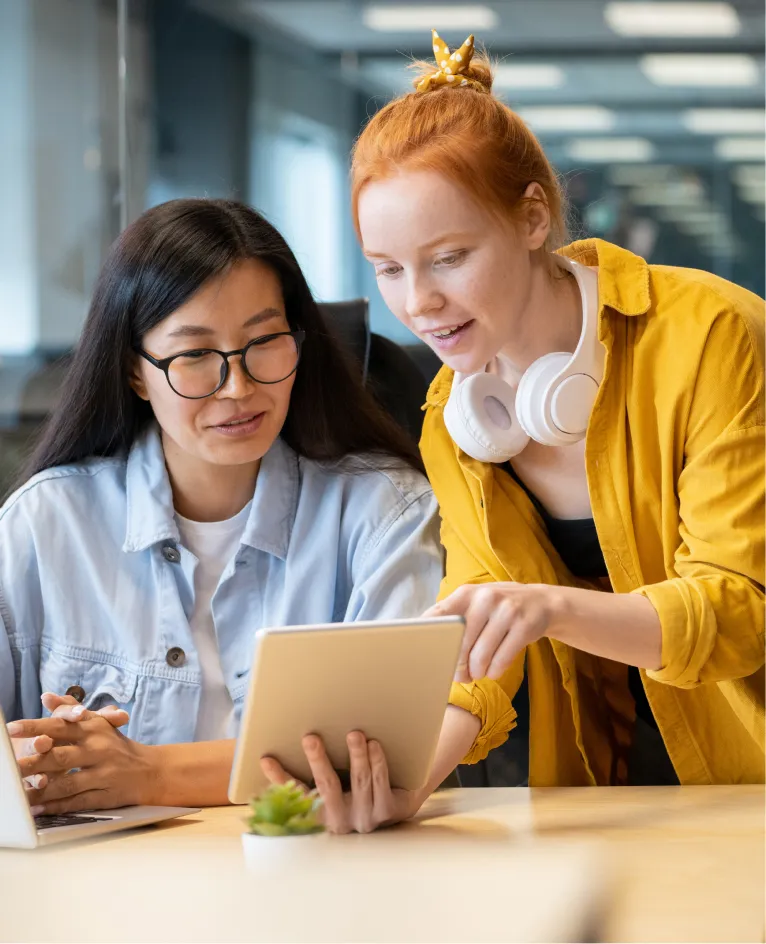 Two colleagues smiling at a tablet