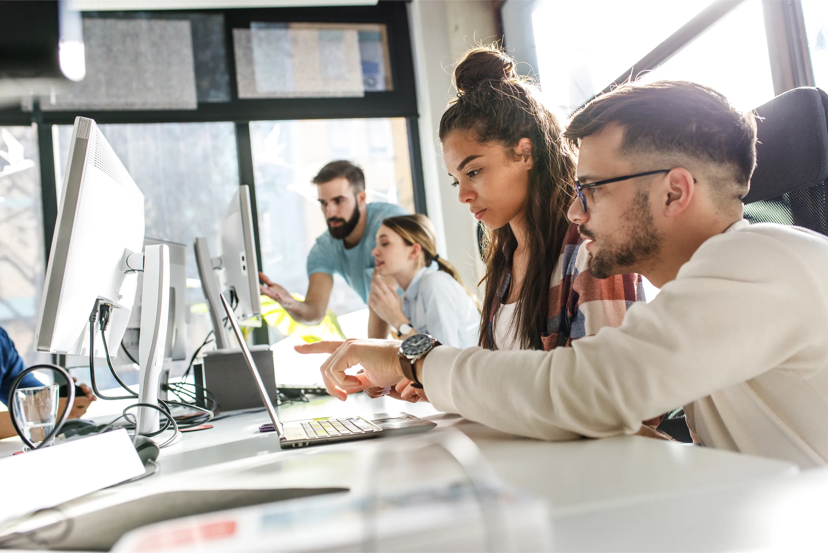 Team collaborating at computers in an office