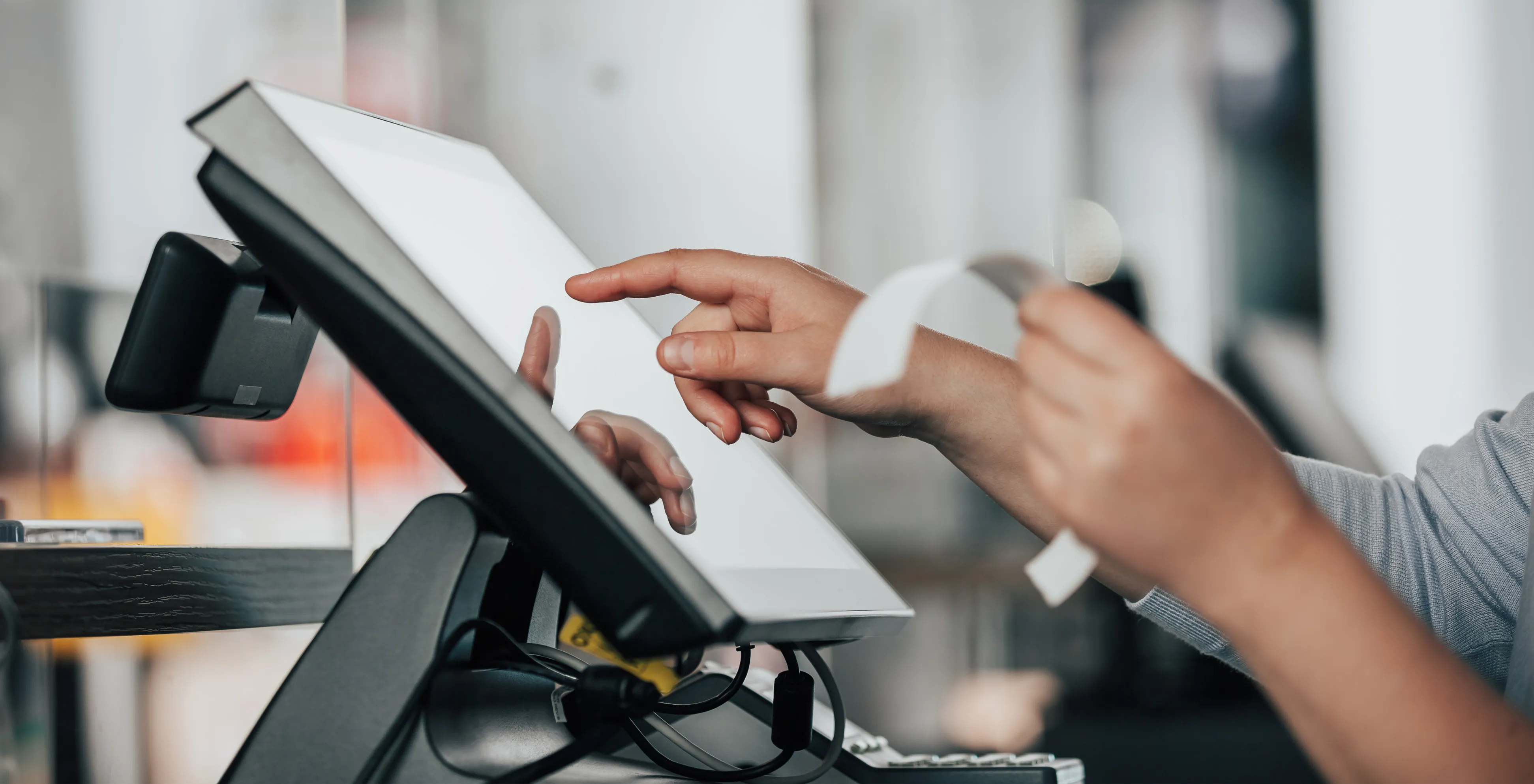 Hand taking a receipt from a point-of-sale terminal