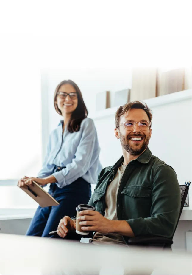 Two colleagues chatting, one holding a tablet