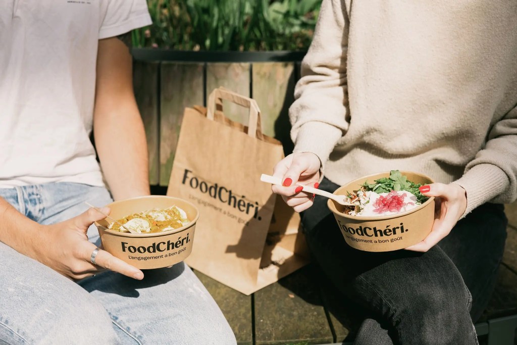 Deux collègues déjeunent au bureau grâce à FoodChéri qui leur permet d'avoir une alimentation équilibrée.