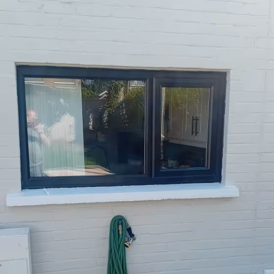 Before image of Older black window before replacement glazing work in Northern Ireland