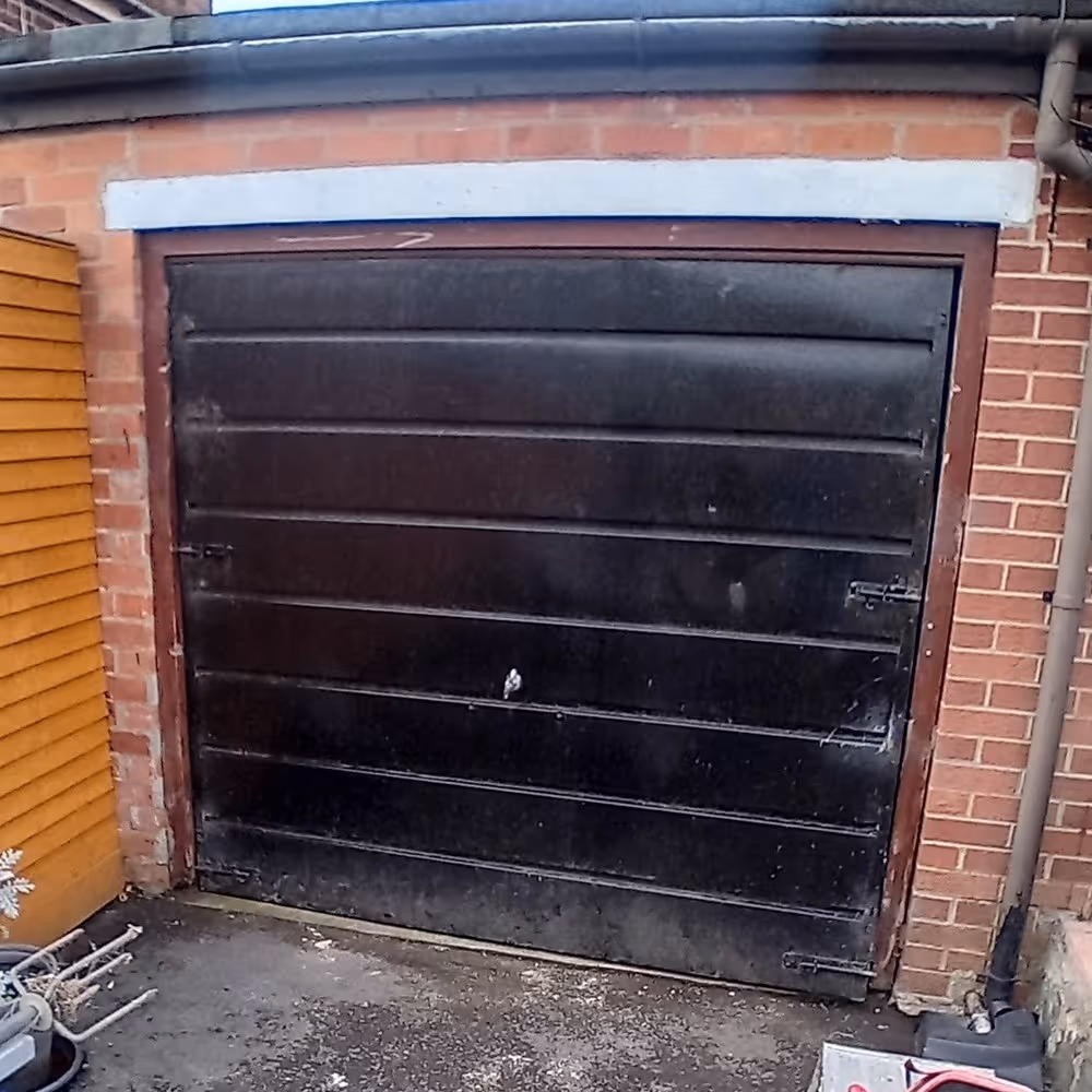 Before photo of old garage door before conversion to French doors