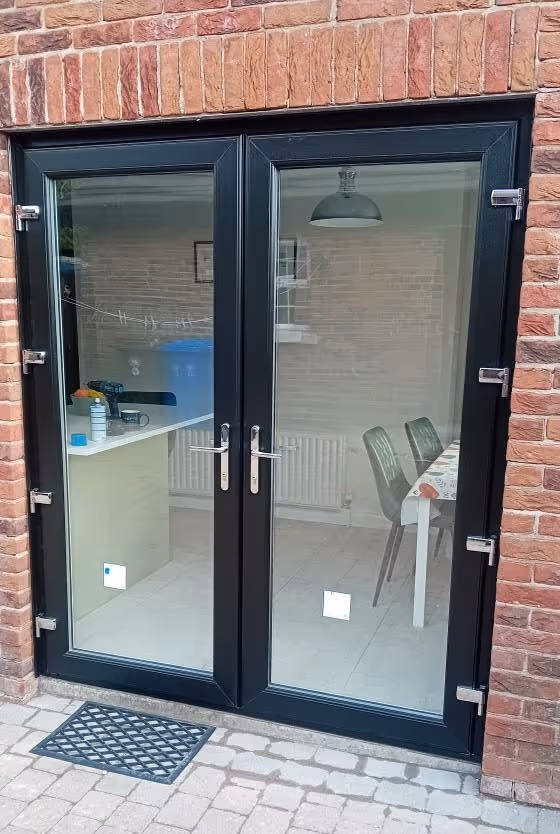 Black uPVC French doors fitted at the back of a brick house in Belfast