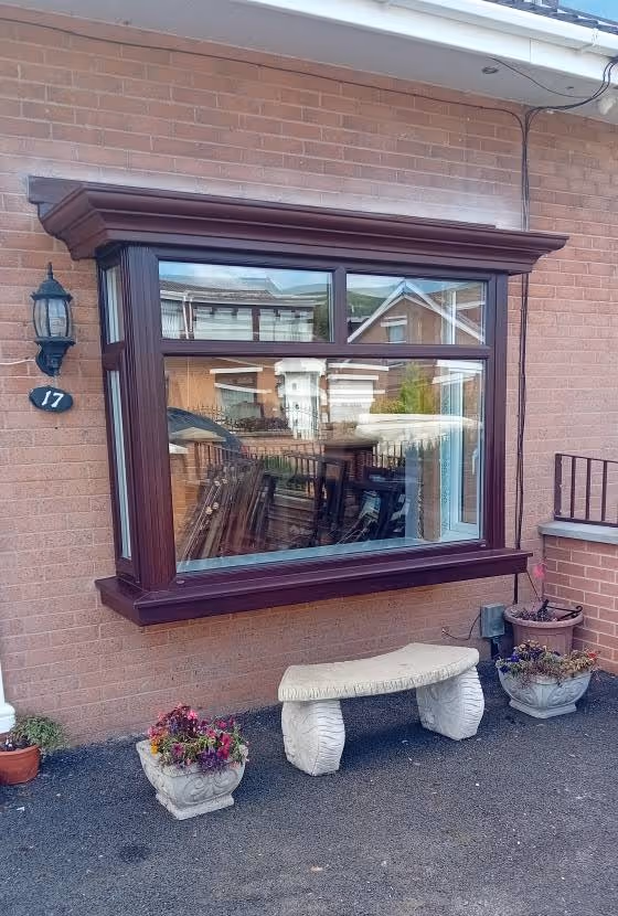 Brown uPVC bay window fitted on the front of a brick house
