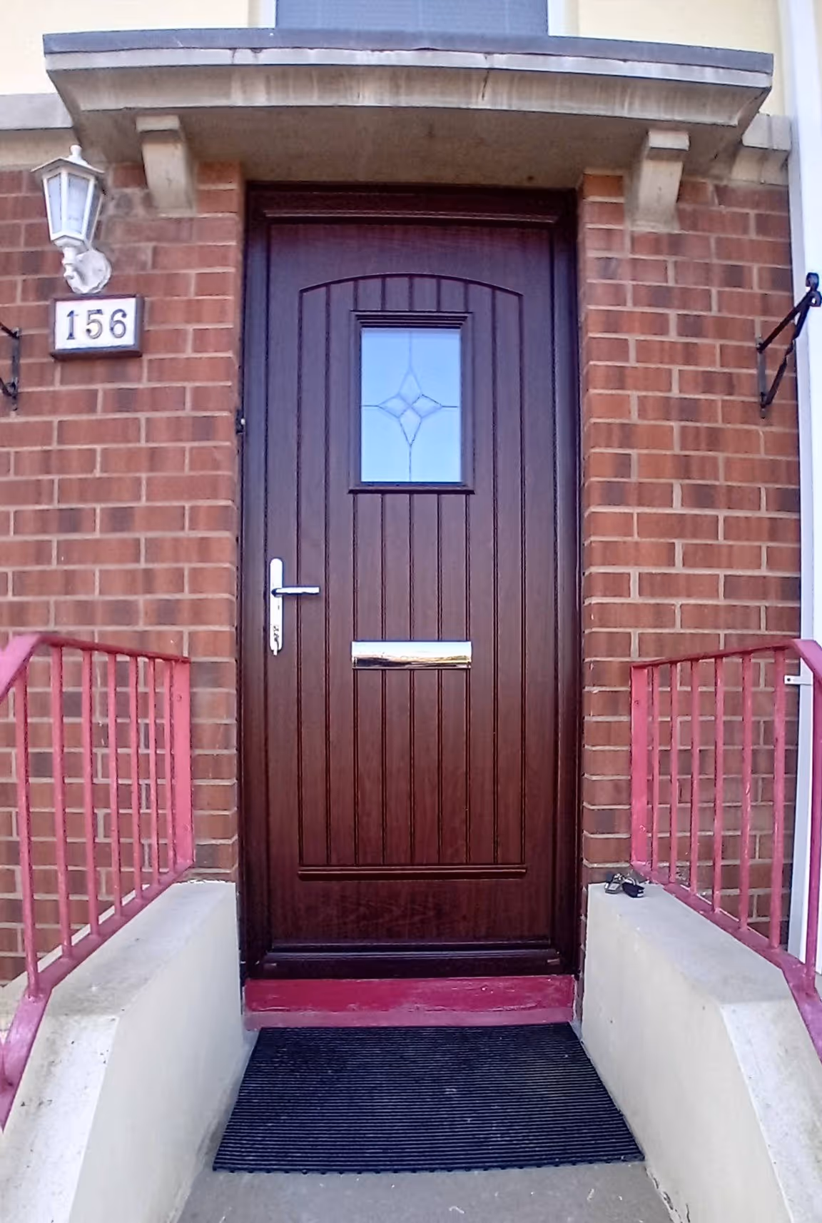 Brown uPVC front door fitted with small decorative glass panel
