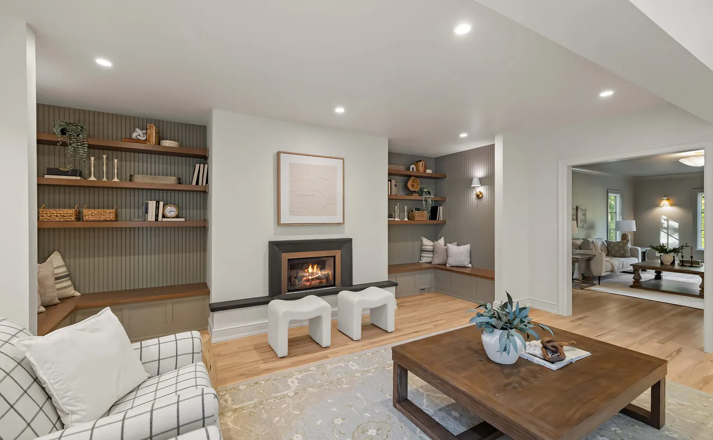 Cozy living room with a fireplace, built-in shelves, wooden coffee table, and a plaid armchair.