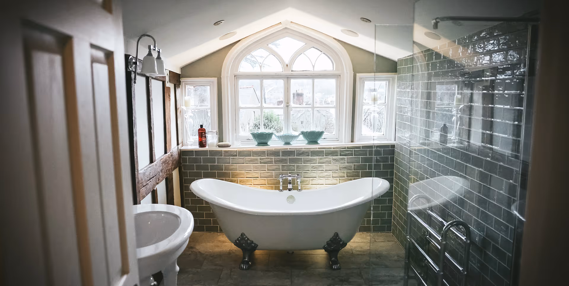 Luxury bathroom with freestanding clawfoot bath and arched window