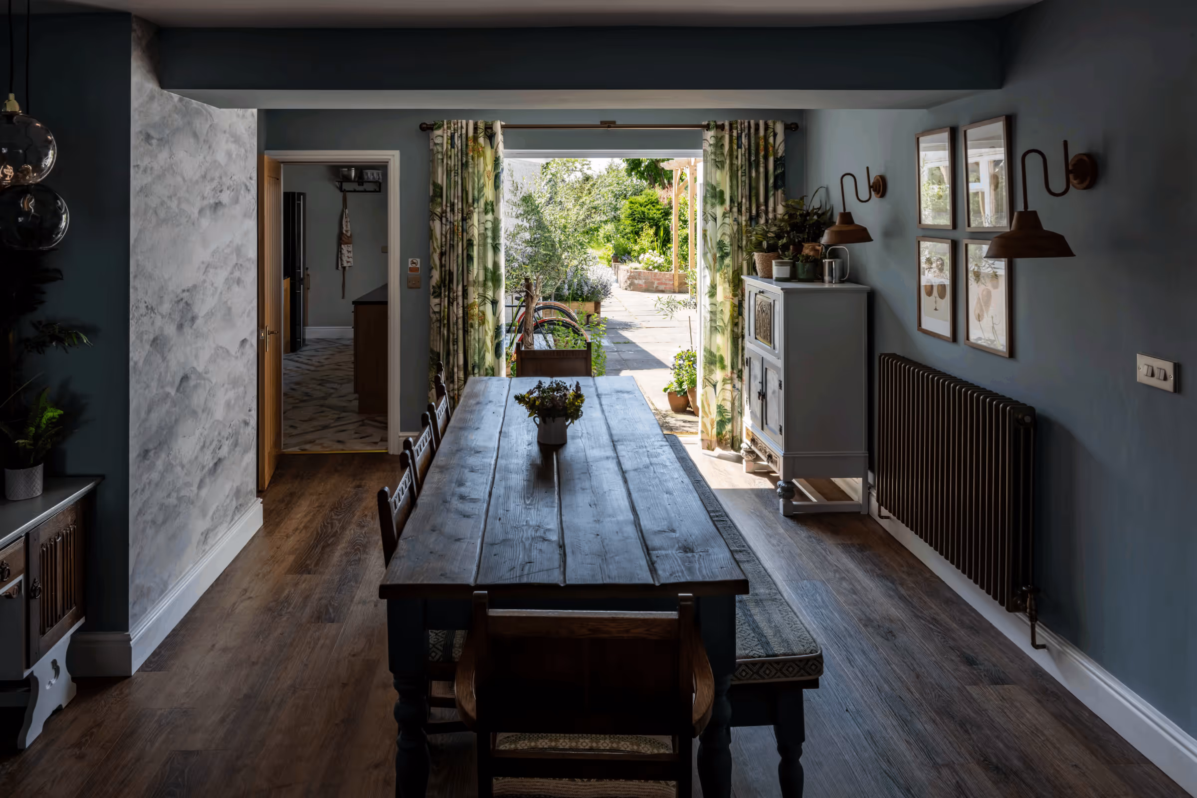 Long farmhouse dining table in a room with open doors to the garden