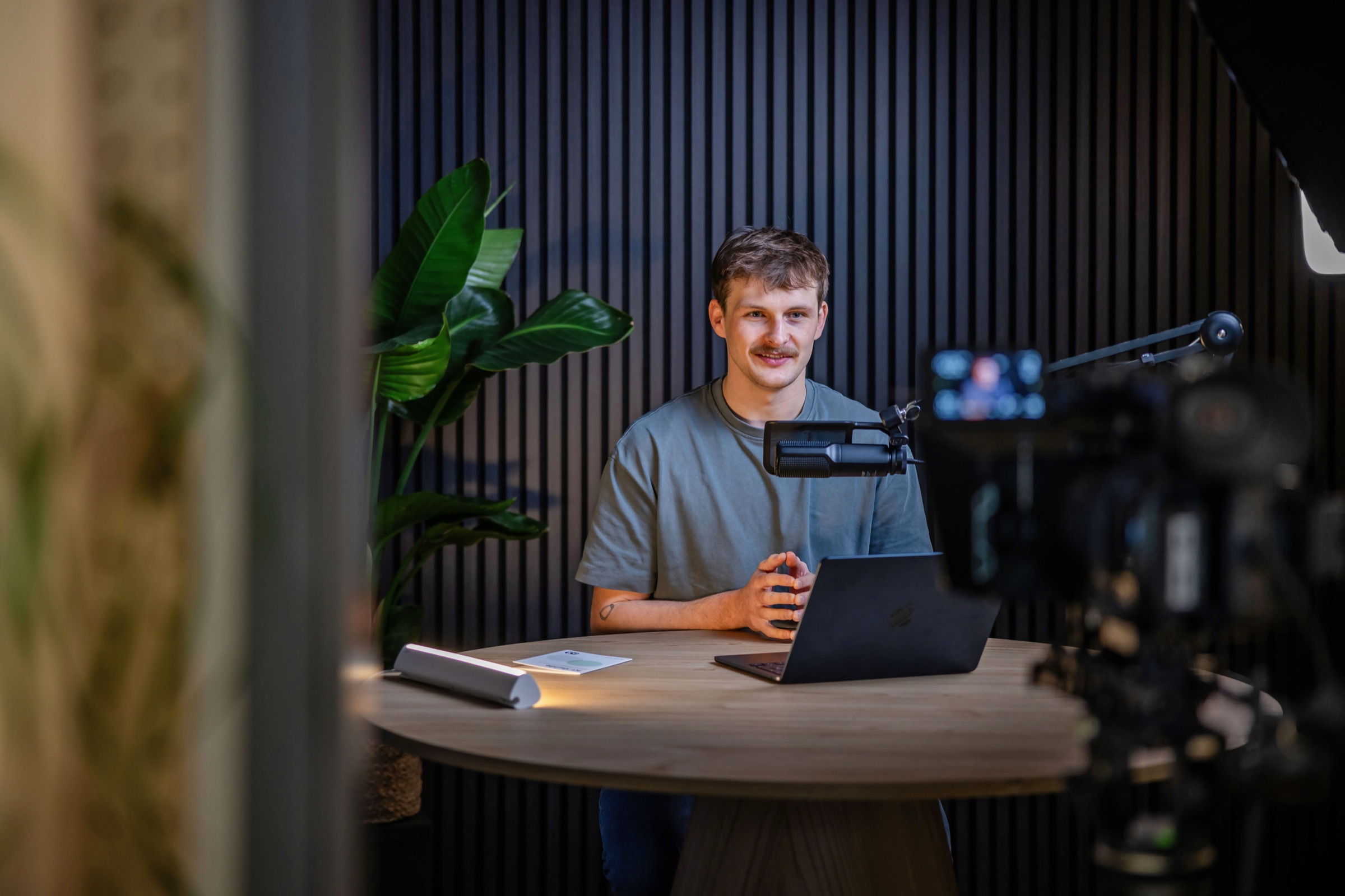 Teammitglied des KI-Studios am Laptop bei einer Videoaufnahme