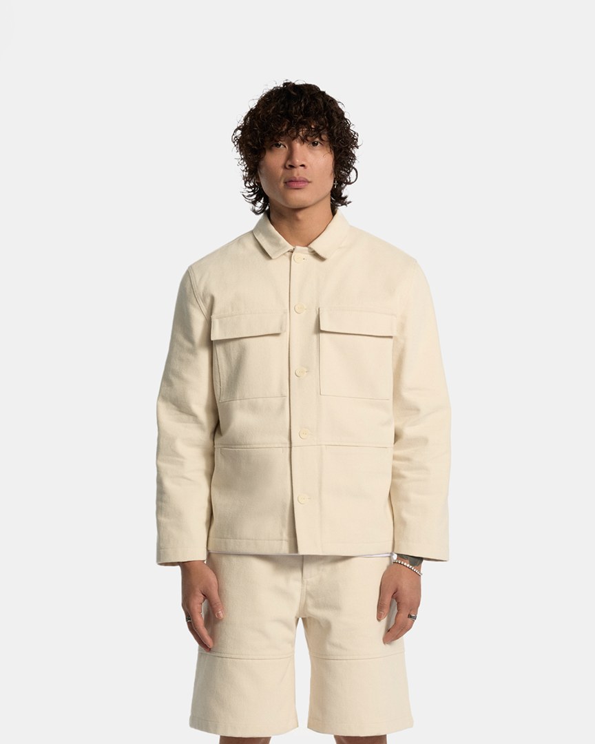 Odd Universe model in a cream branded jacket and trousers from the merch range