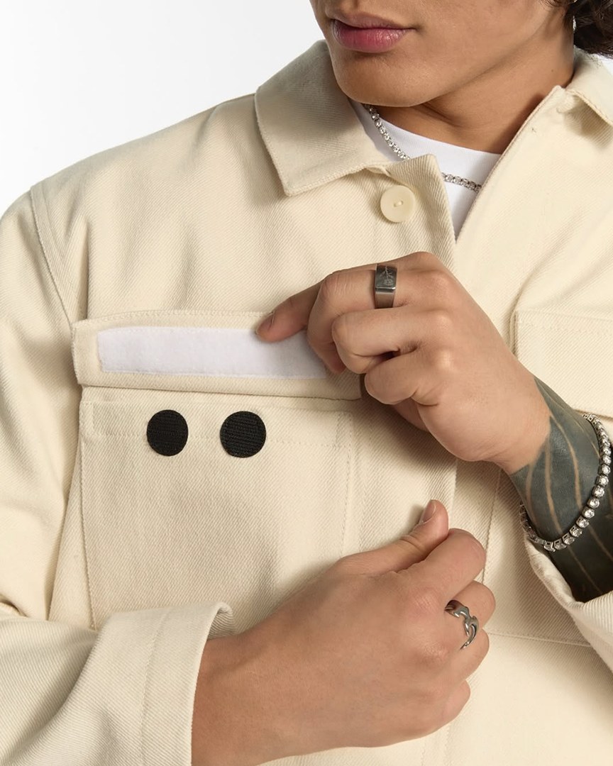 Odd Universe close-up of a cream jacket with ou branded buttons