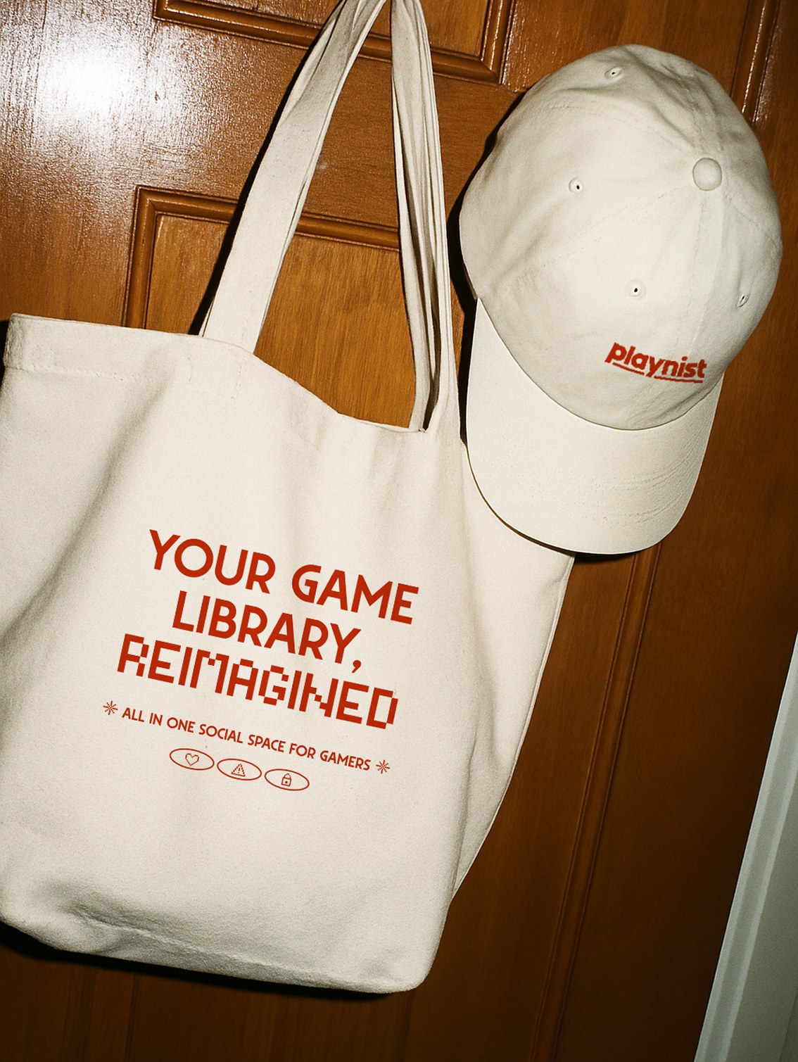 Playnist merchandise — a cream 'Your Game Library Refreshed' tote bag and embroidered cap