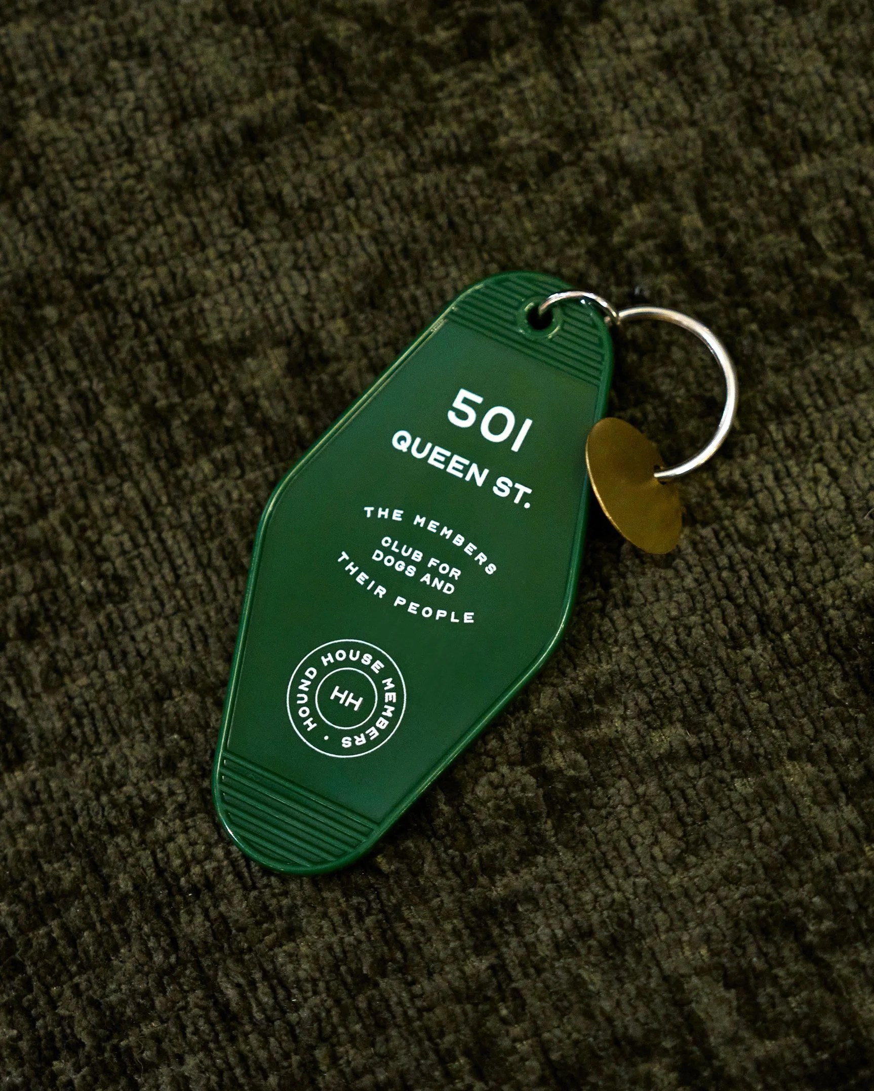 Hound House dark green branded keyring tag with the logo, on a black background