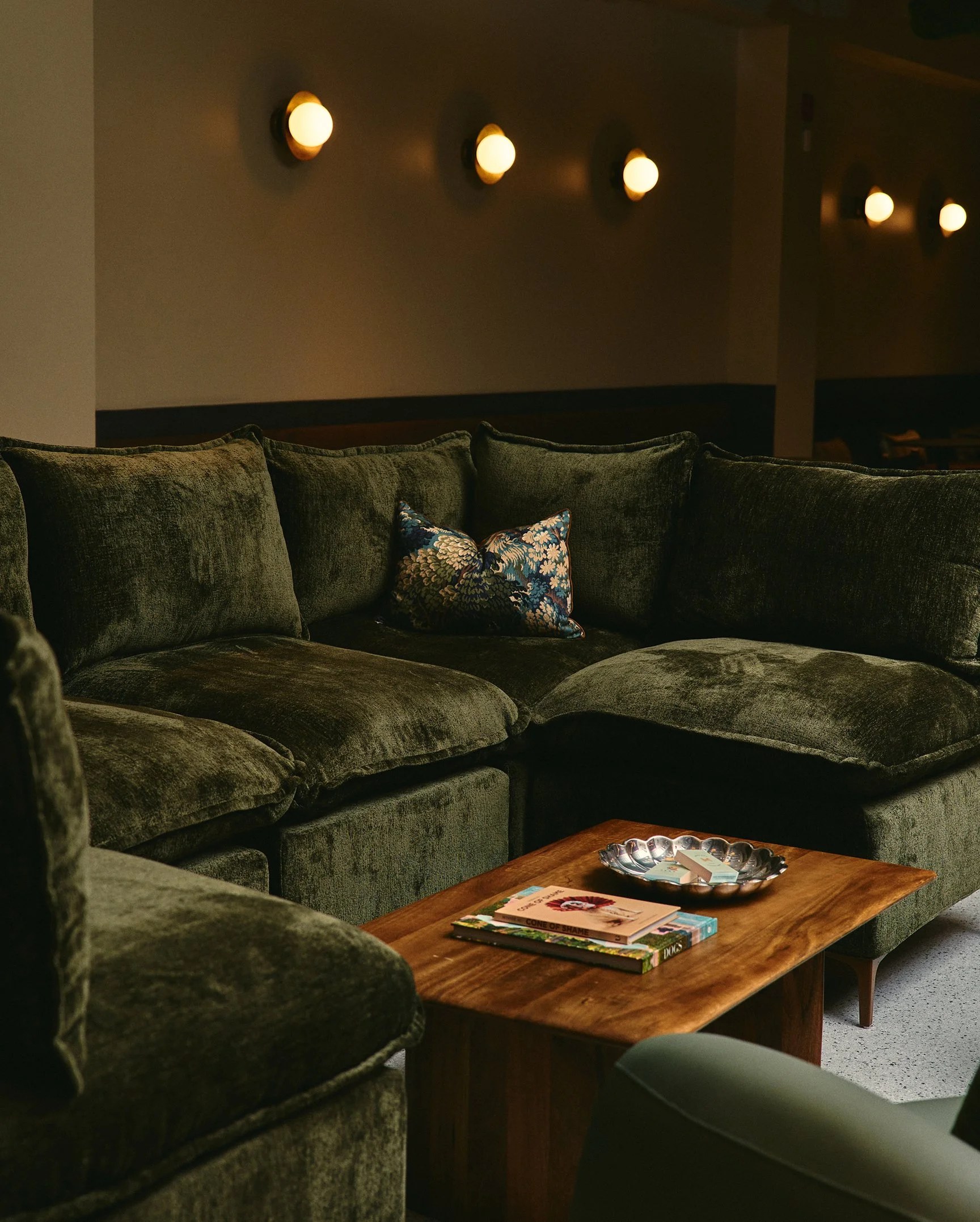 Hound House interior photography — a plush green velvet sofa in the members space