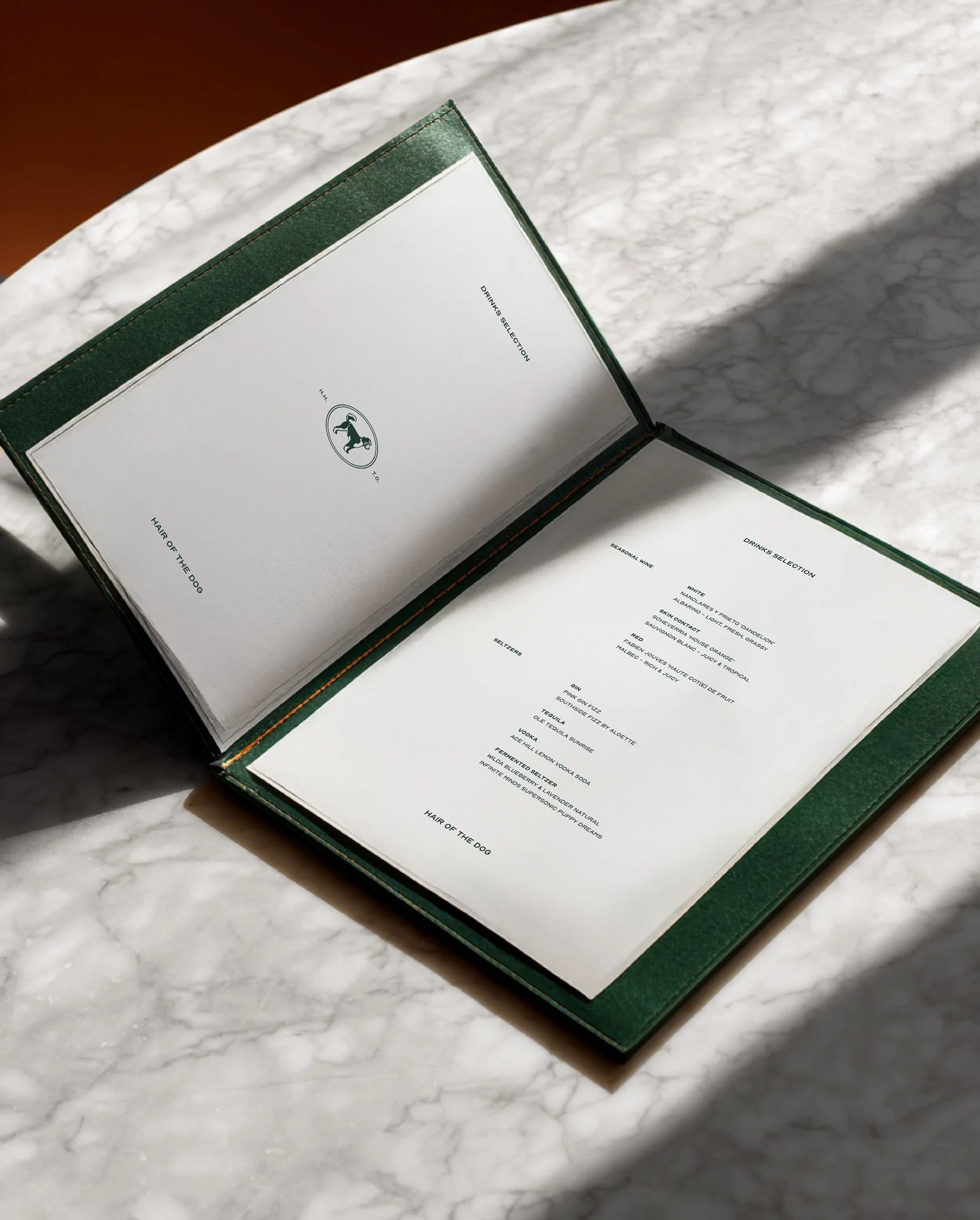 Hound House menu held over a marble table