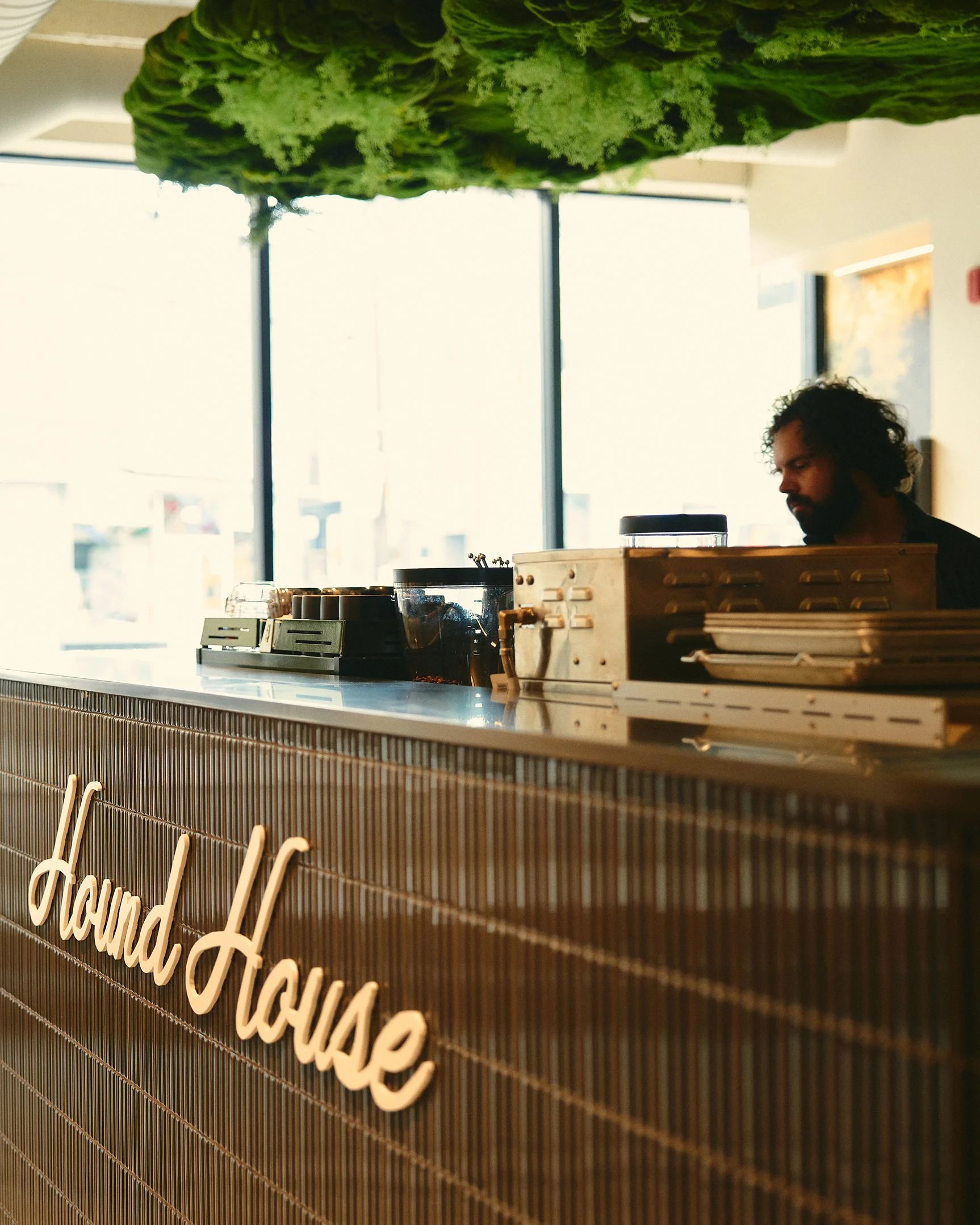 Hound House green window signage with the cursive wordmark