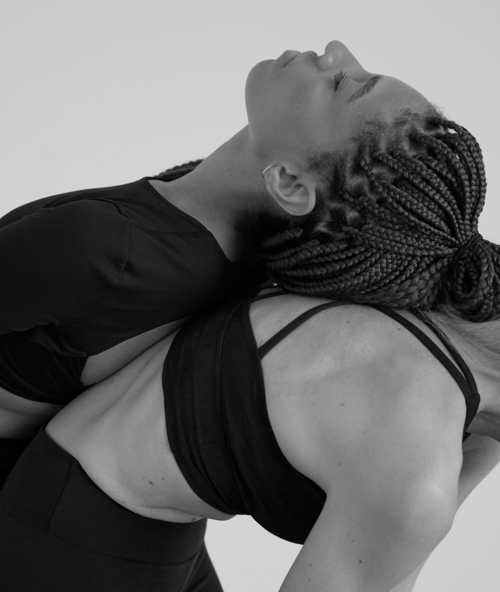 Kore Pilates editorial photography — a woman stretching in black activewear in moody, soft tones