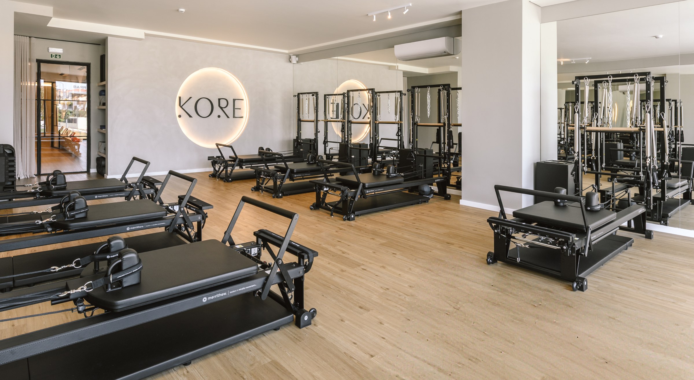 Kore Pilates studio interior with rows of reformers and the circular wall logo