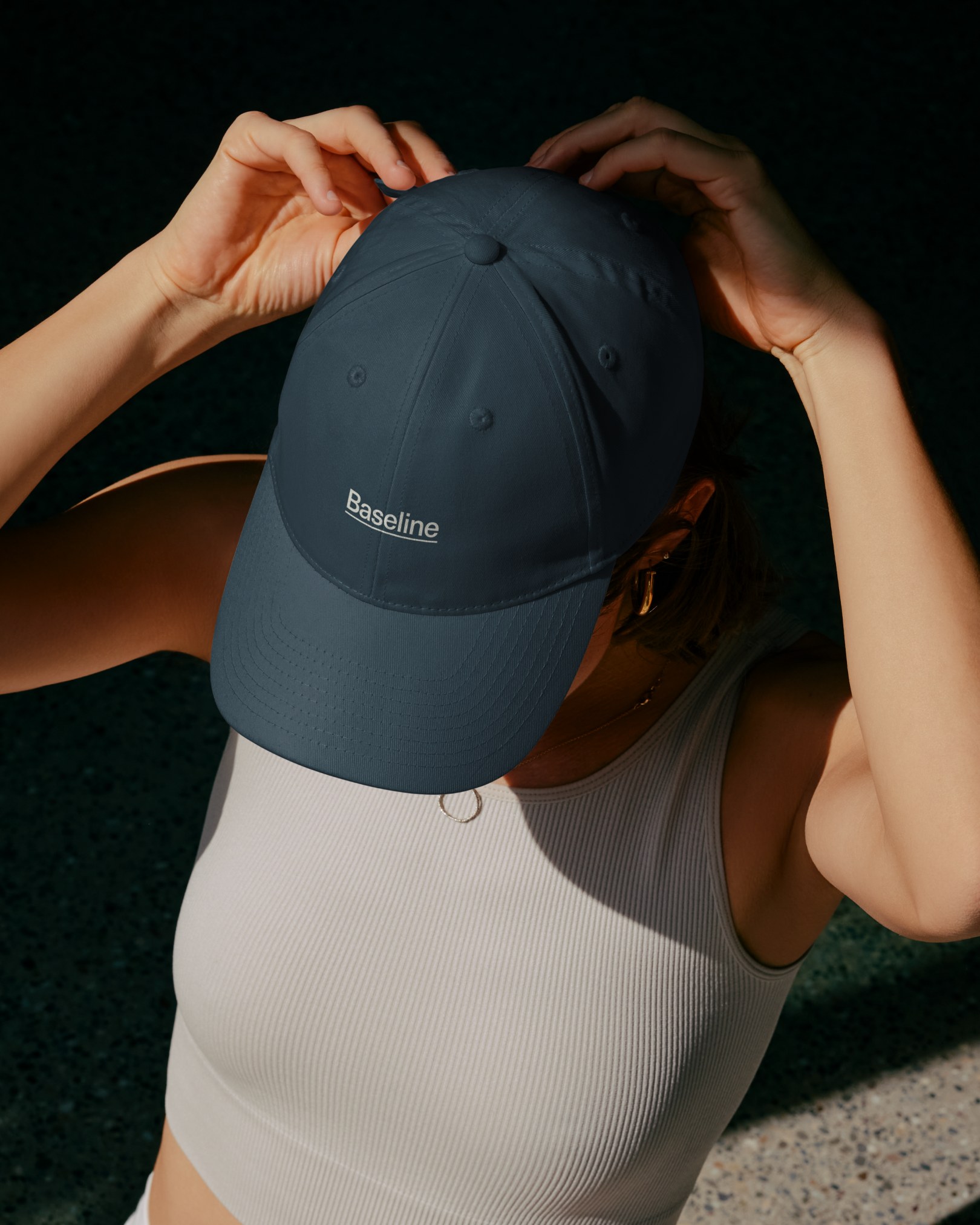 Baseline lifestyle photography of a person in a cap and activewear seen from behind