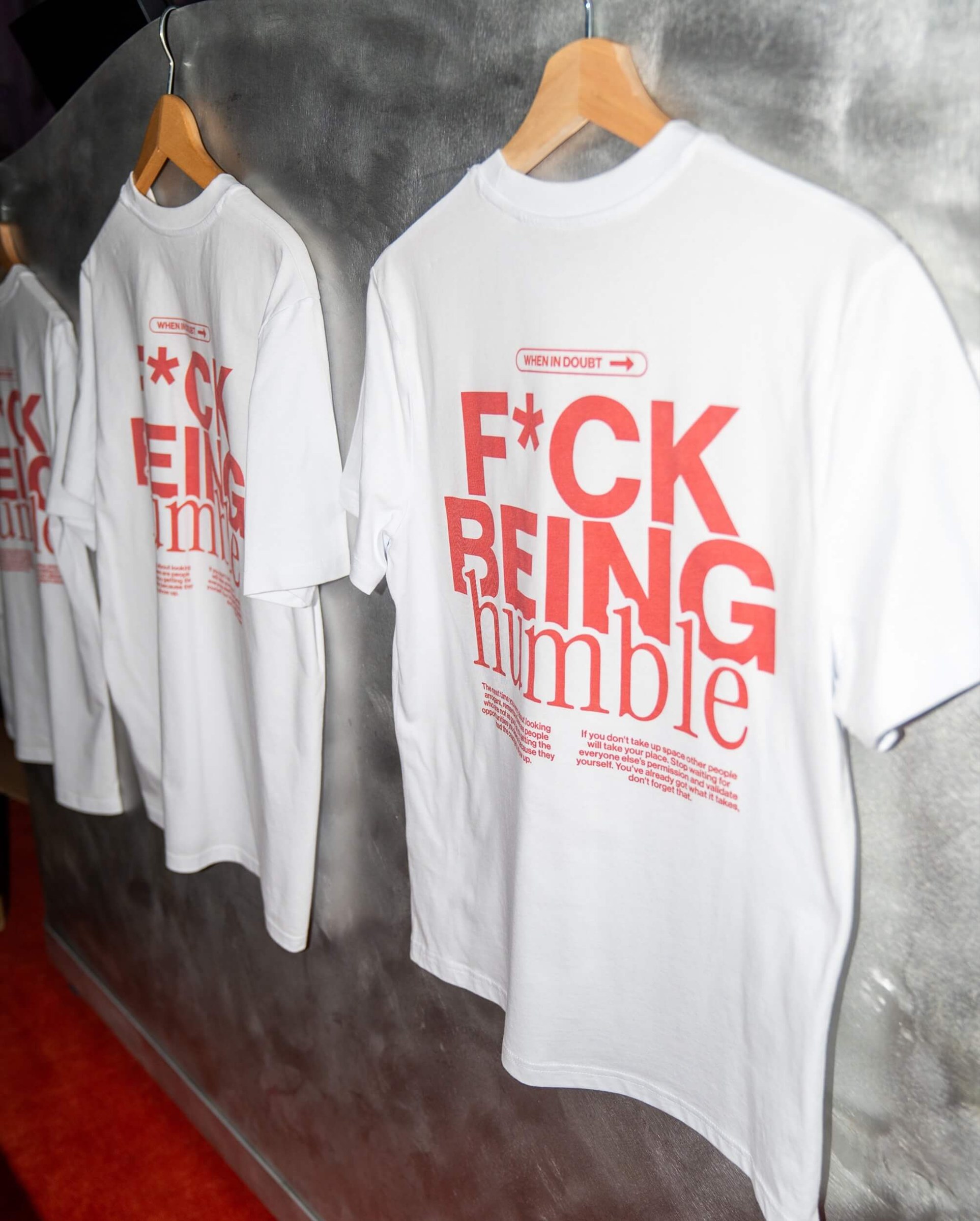 F*ck Being Humble white t-shirts on a clothing rail