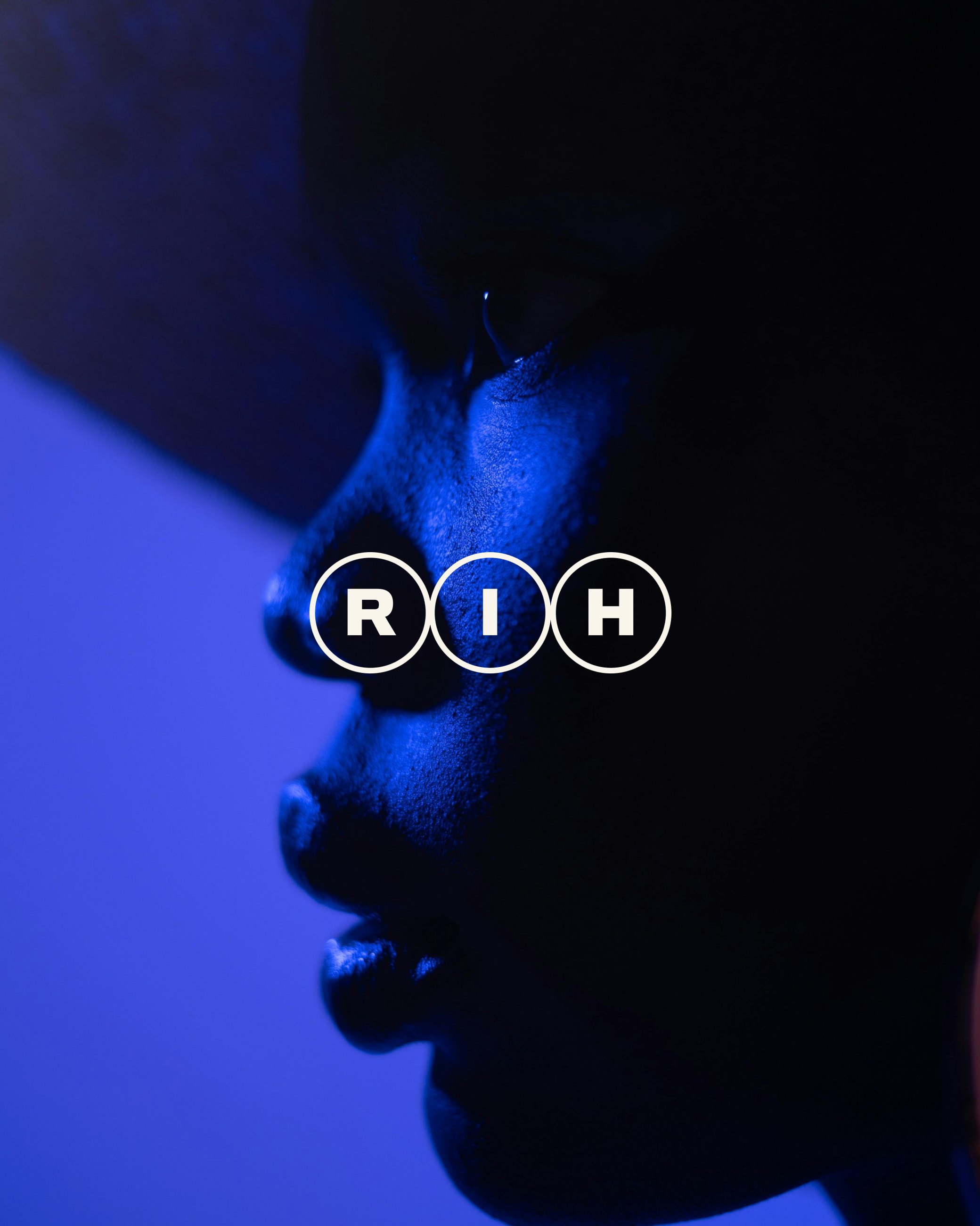 Real Impact Hub monogram over a blue-lit profile portrait