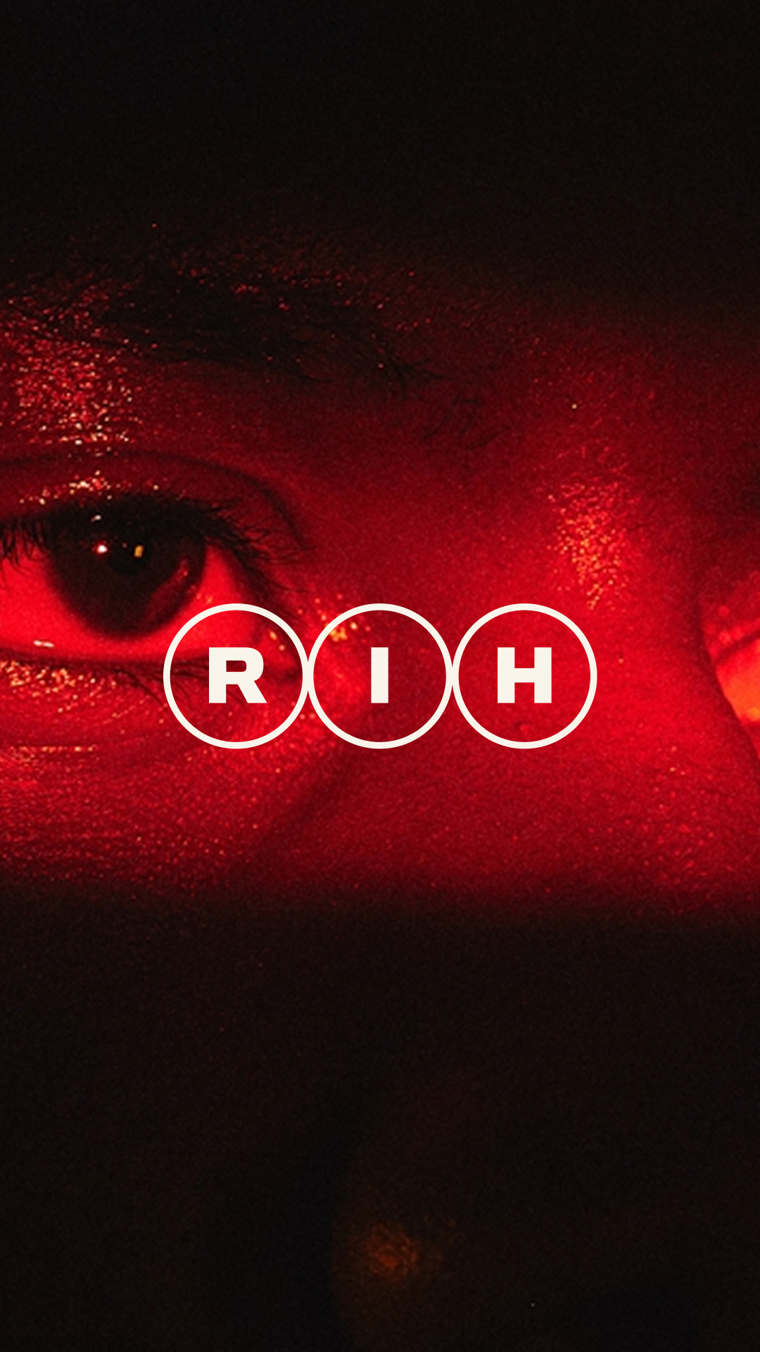 Real Impact Hub RIH monogram over a close-up red-lit portrait
