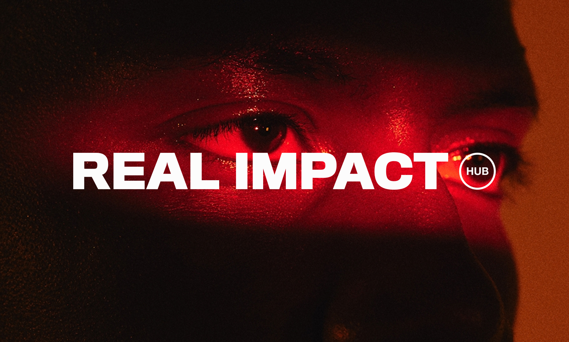 Real Impact Hub wordmark over a close-up portrait lit in red