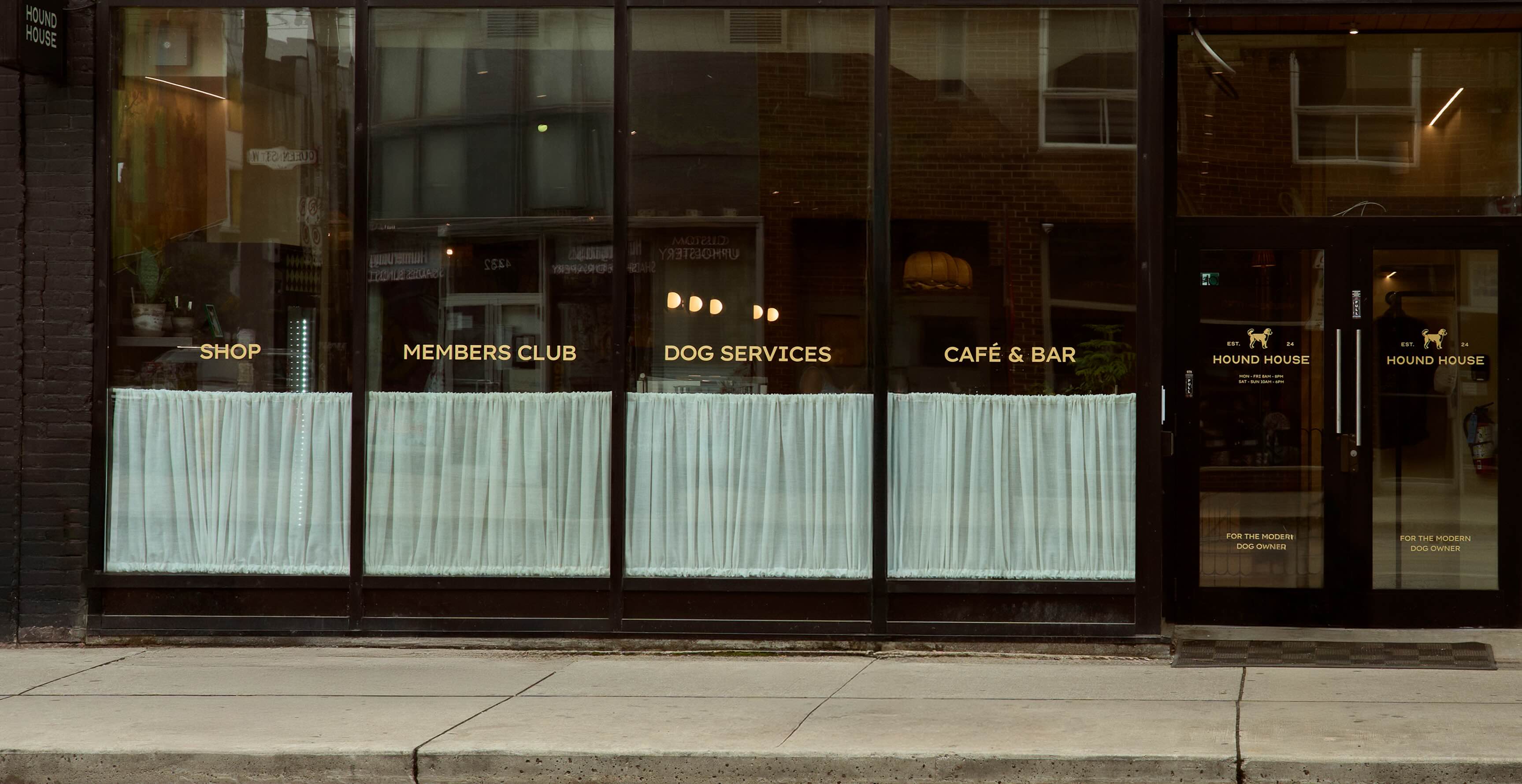 Hound House shopfront with window signage for the shop, members club, dog services and café and bar