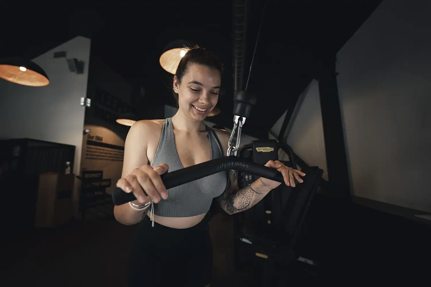 Femme souriant utilisant tapis roulant en salle de sport Keepcool pour adapter son entraînement cardio.